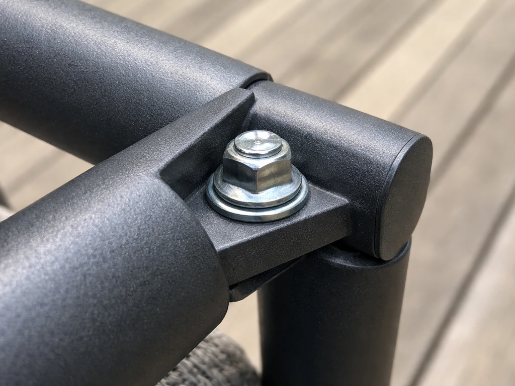 Close-up of a patio frame corner joint with hex/carriage bolt, washer, and lock nut on metal tubing.