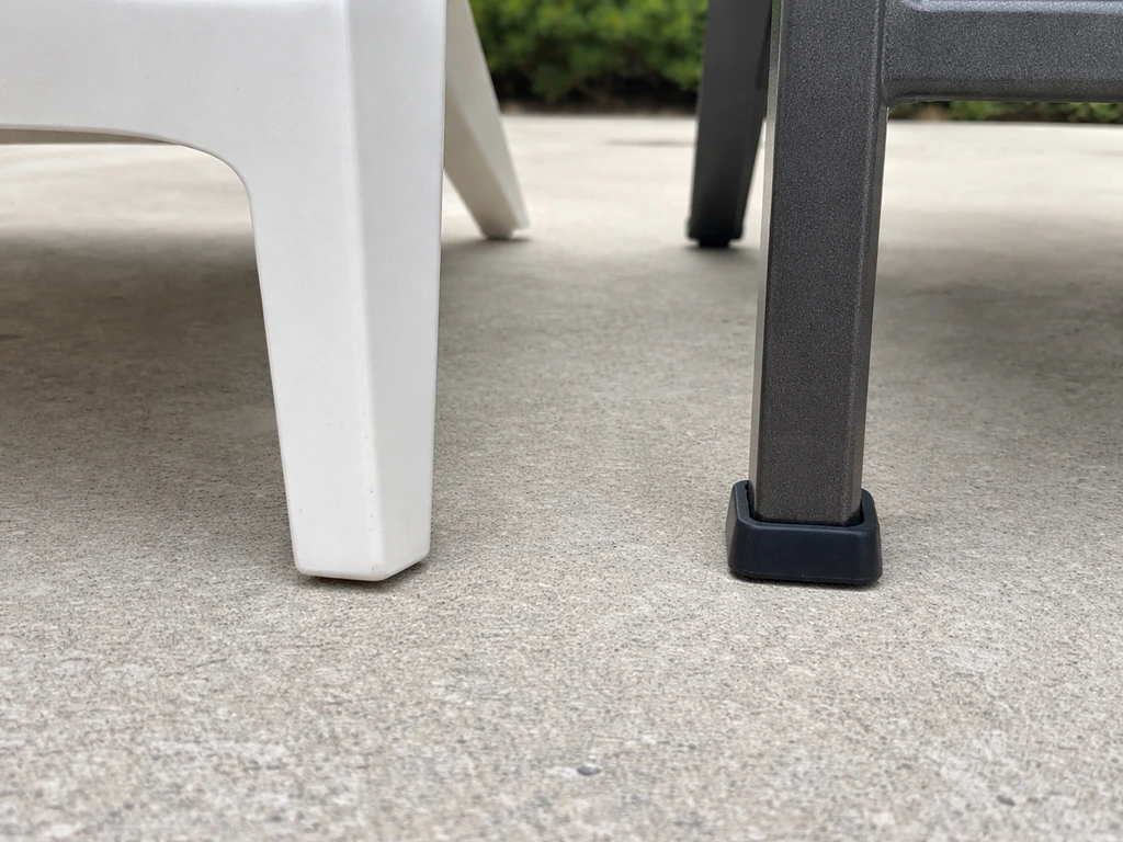 Close-up of two patio chairs’ feet on concrete, showing lighter plastic vs heavier metal leg contact.